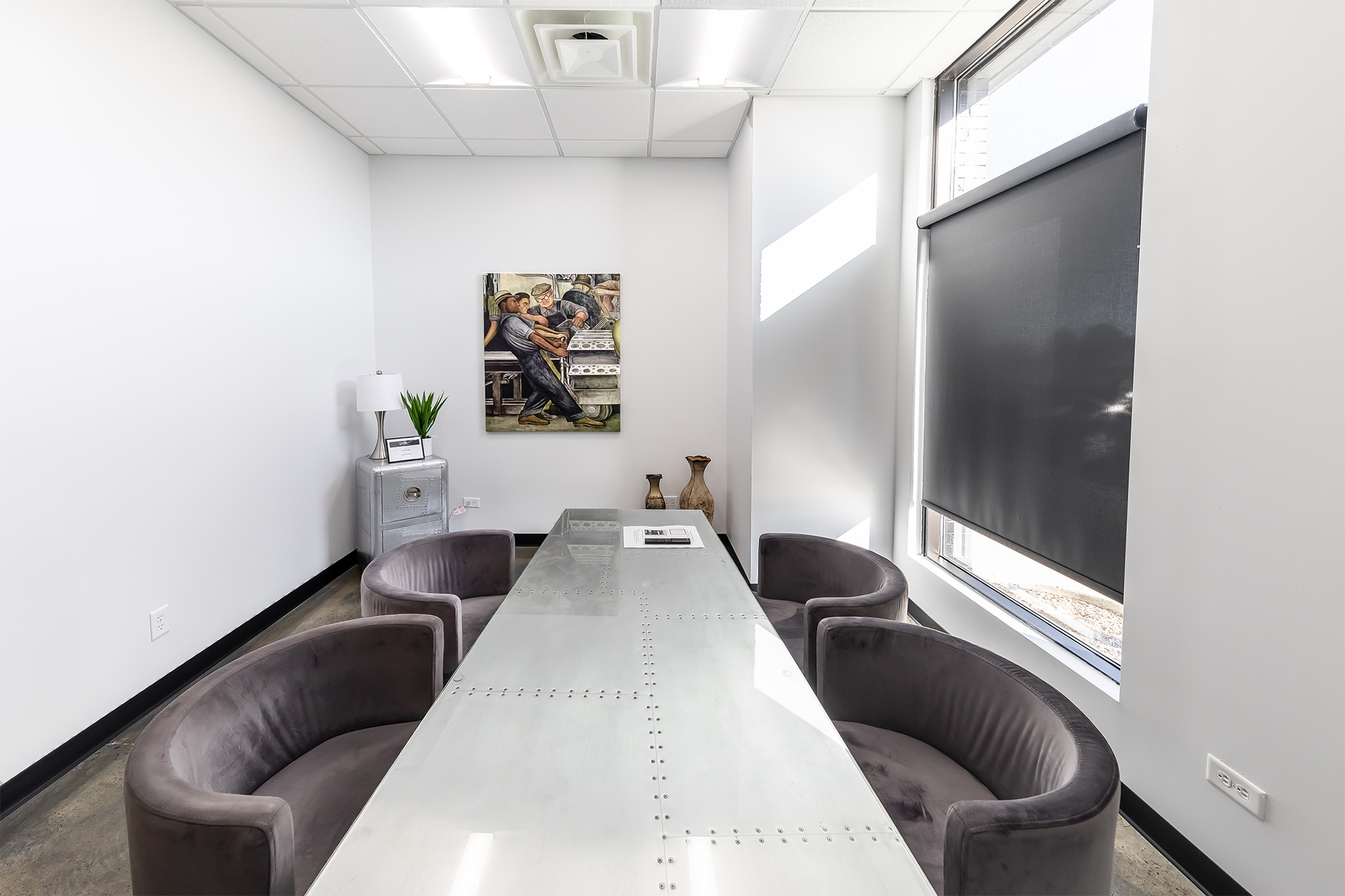 Meeting room with long table and four comfy chairs