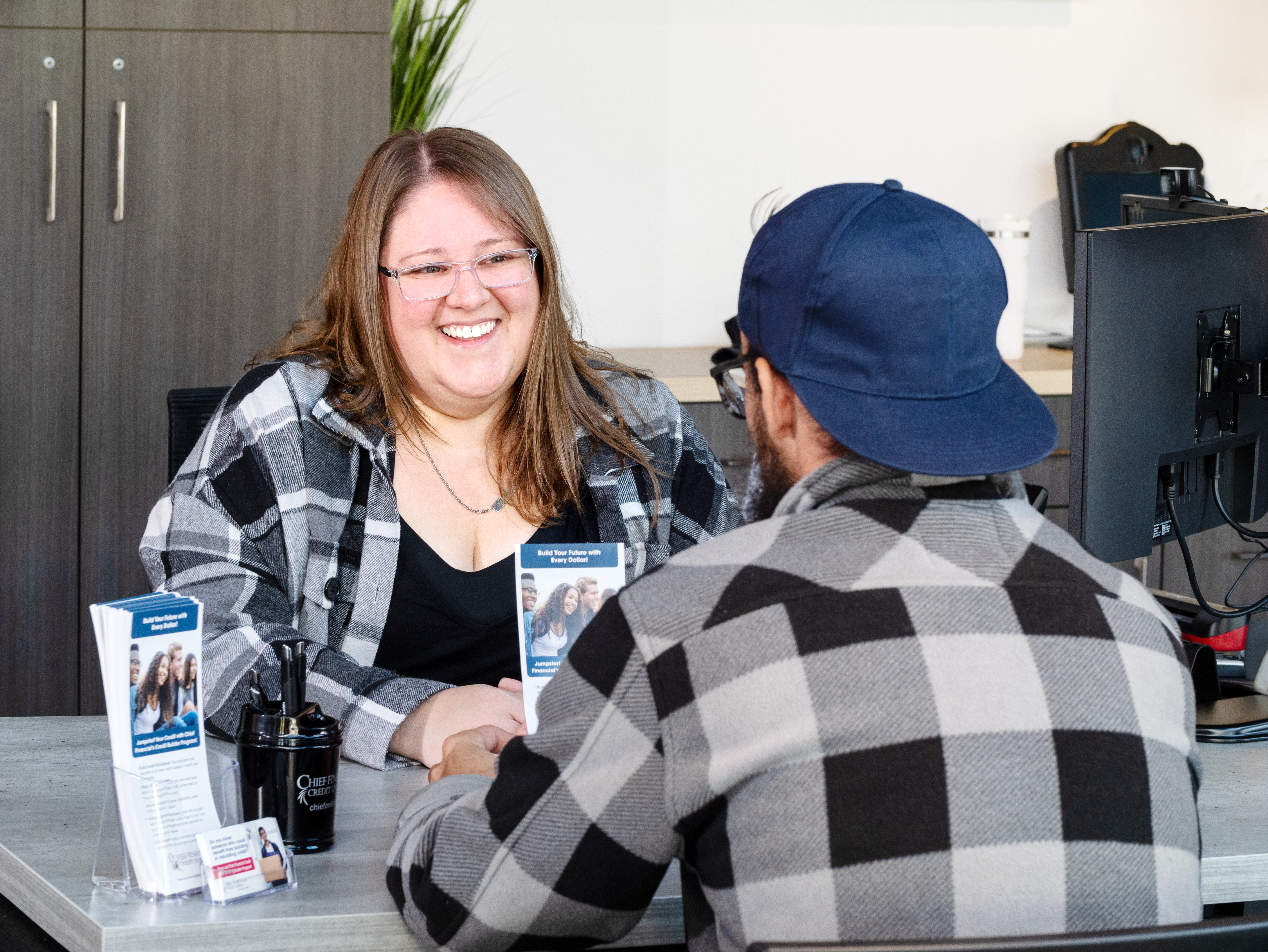 Woman at a desk smiling at a man sitting across from her